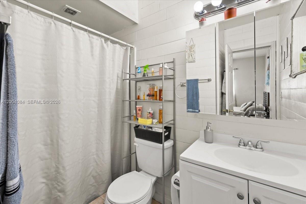 9025 Southwest 36th Street Miami, FL 33165 - Photo 12 of 20 a bathroom with a sink a toilet and shower curtain