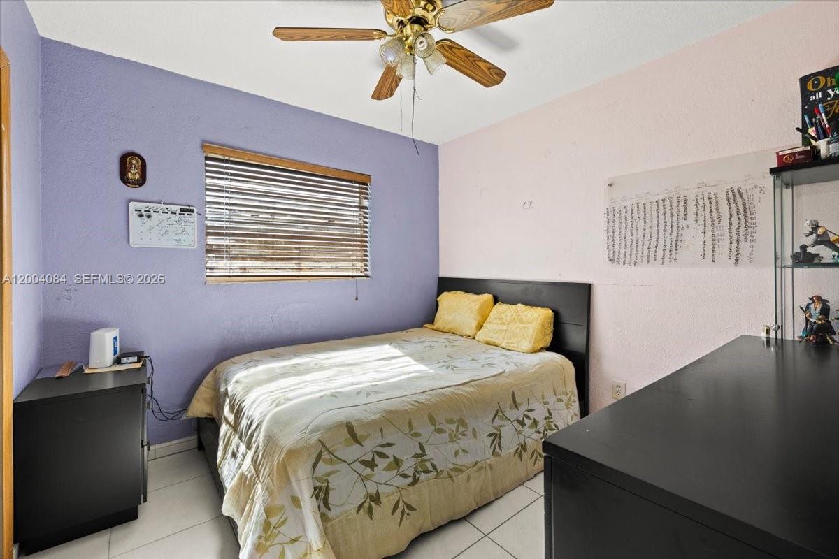 9025 Southwest 36th Street Miami, FL 33165 - Photo 13 of 20 a bedroom with a bed and a chandelier
