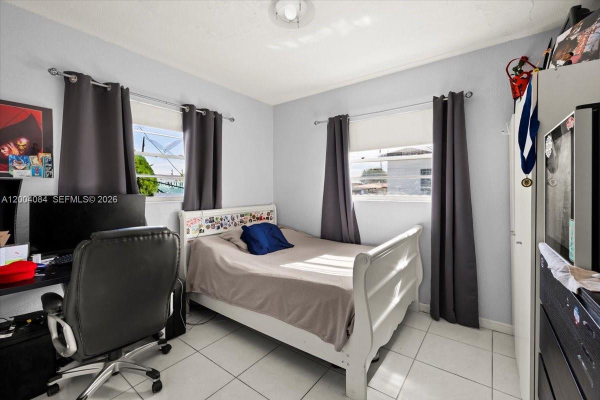 9025 Southwest 36th Street Miami, FL 33165 - Photo 14 of 20 a bedroom with a bed tv and a window