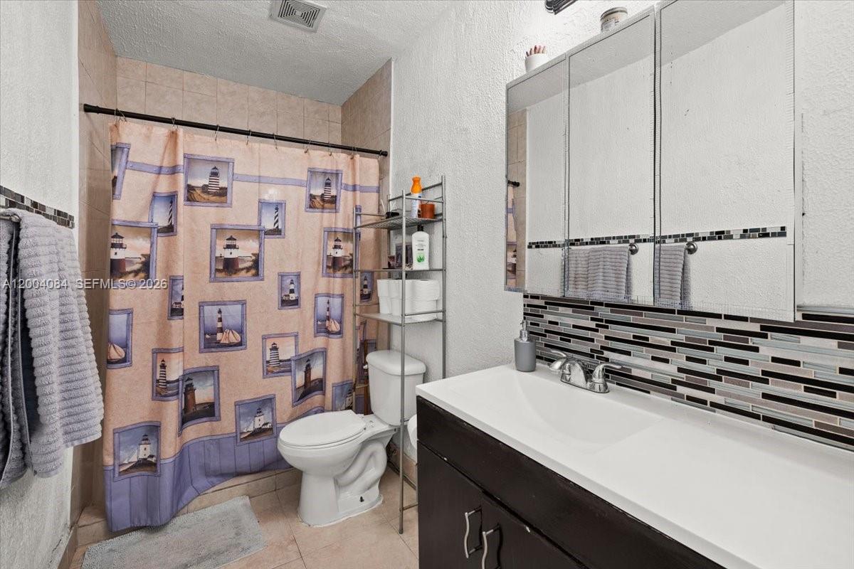 9025 Southwest 36th Street Miami, FL 33165 - Photo 15 of 20 a bathroom with a sink toilet and shower