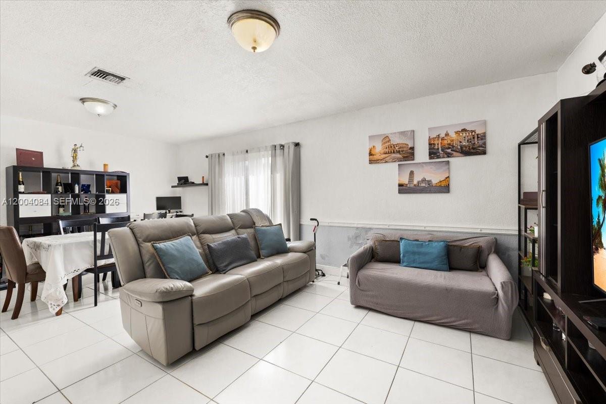 9025 Southwest 36th Street Miami, FL 33165 - Photo 3 of 20 a living room with furniture and a flat screen tv
