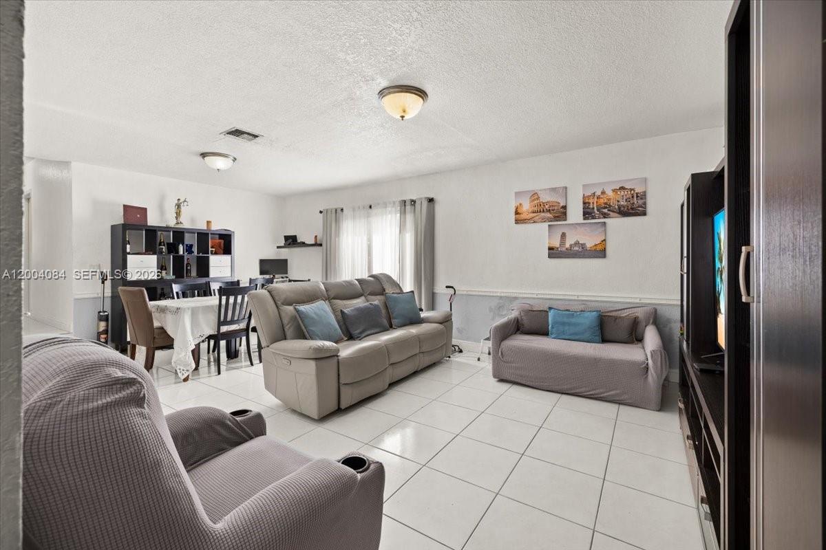 9025 Southwest 36th Street Miami, FL 33165 - Photo 4 of 20 a living room with furniture and a refrigerator