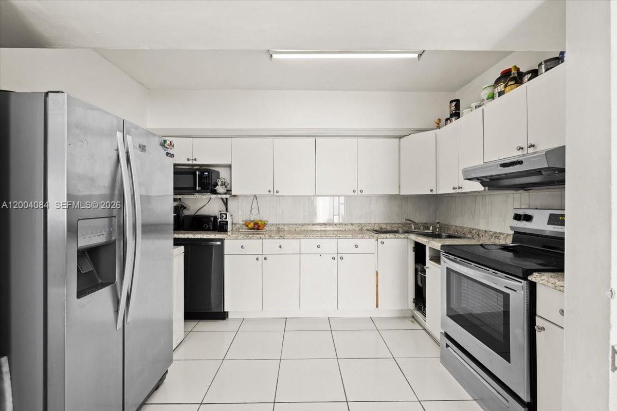 9025 Southwest 36th Street Miami, FL 33165 - Photo 6 of 20 a kitchen with stainless steel appliances granite countertop a refrigerator sink and stove