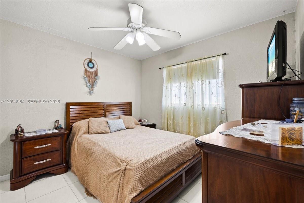 9025 Southwest 36th Street Miami, FL 33165 - Photo 10 of 20 a bedroom with a bed and a chandelier