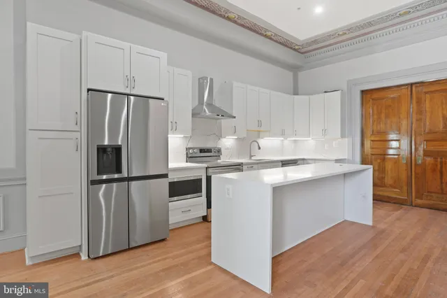 a kitchen with a sink a refrigerator and cabinets