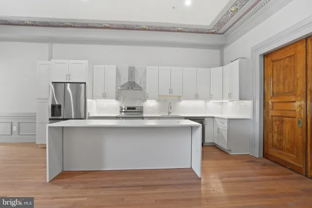 a kitchen with cabinets and wooden floor