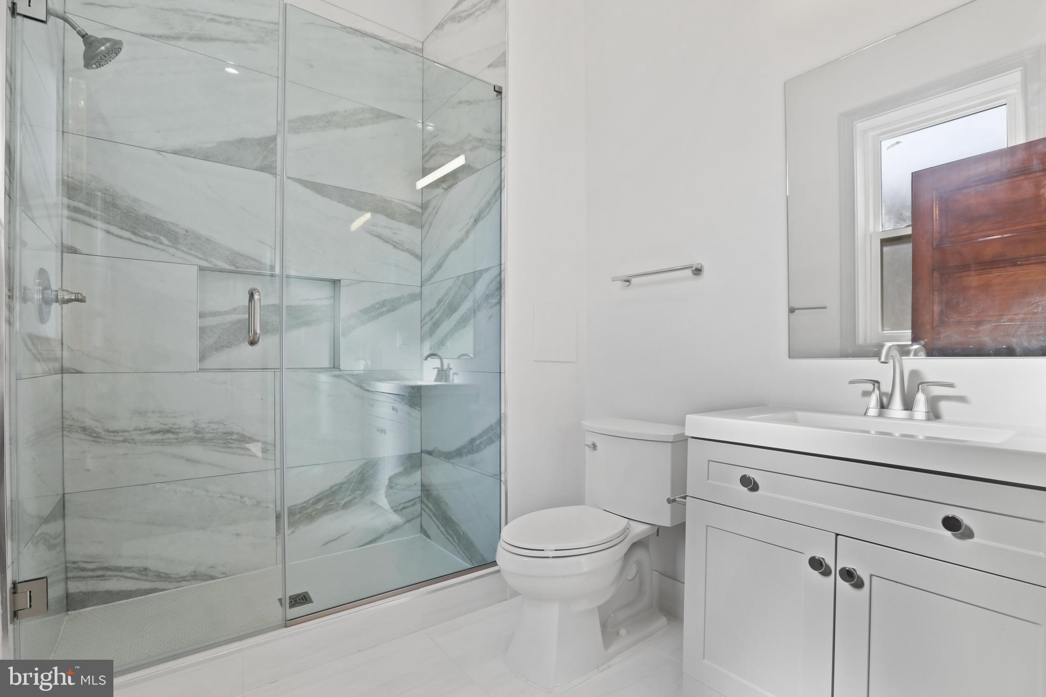 812 Park Avenue, Unit 2FR Baltimore, MD 21201 - Photo 28 of 30 a bathroom with a shower sink mirror and toilet