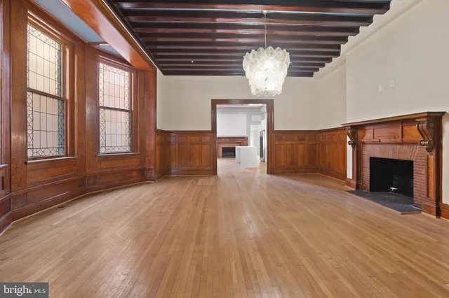 a view of empty room with wooden floor and fireplace
