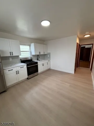 a view of an empty room with a window and fireplace