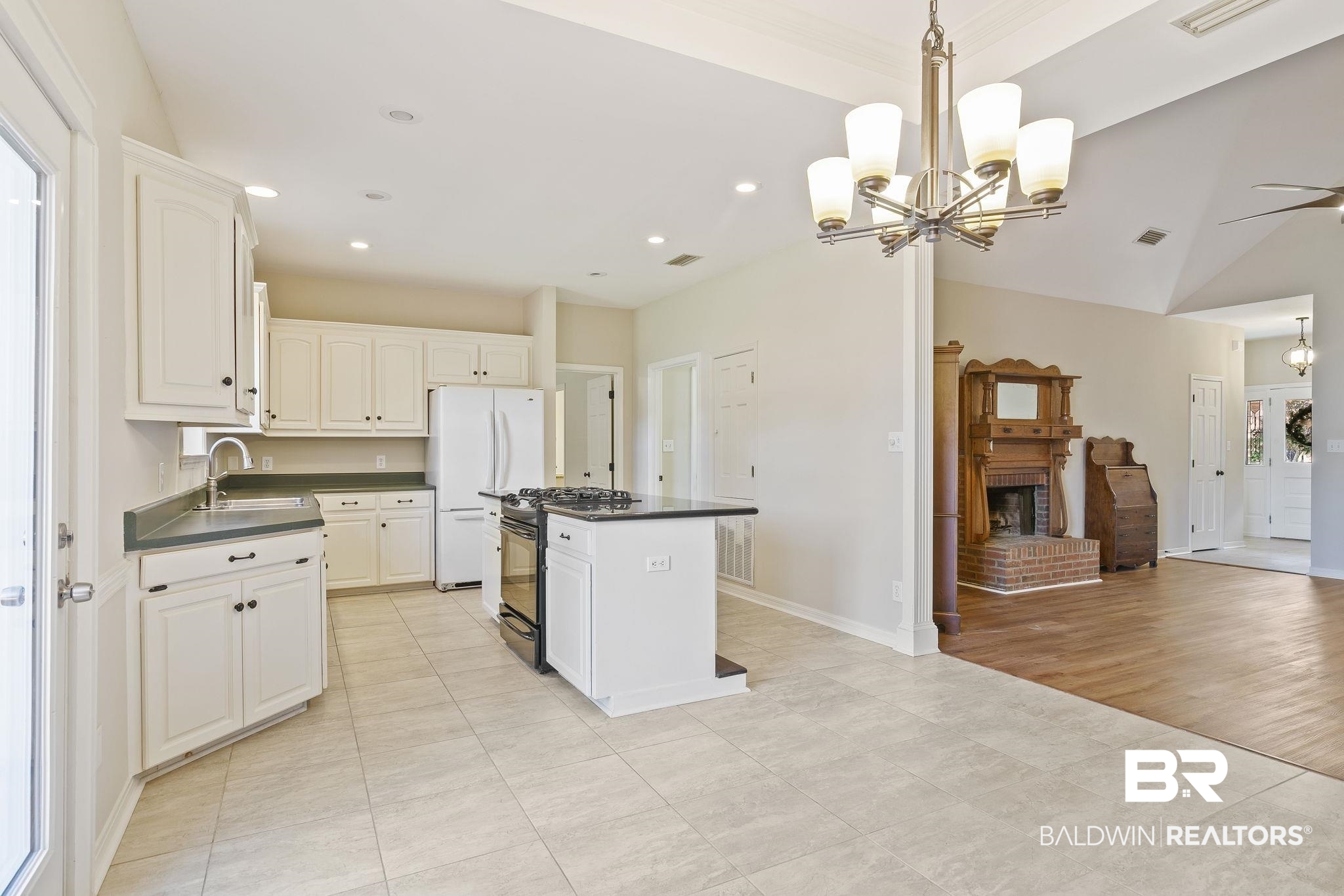 9631 Bay Meadows Avenue Fairhope, AL 36532 - Photo 15 of 49 Kitchen featuring black range with gas stovetop, white refrigerator, light tile floors, and a kitchen island.