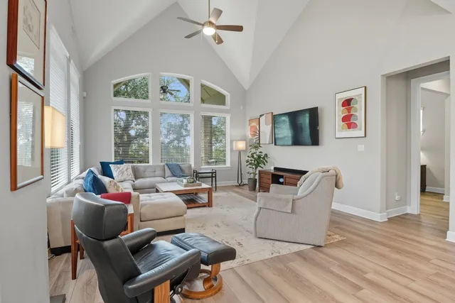 a living room with furniture a flat screen tv and a large window