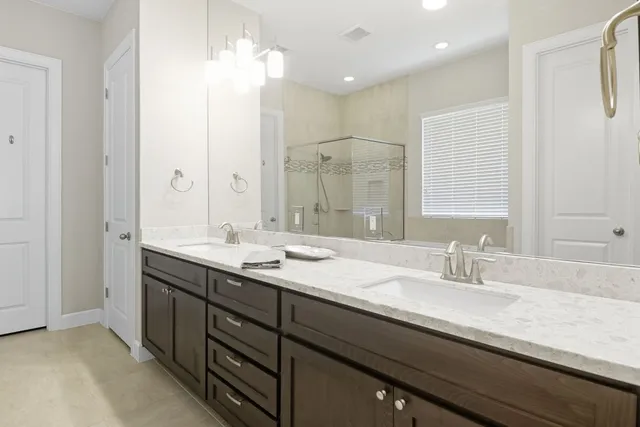 a bathroom with a granite countertop sink a large mirror and a shower