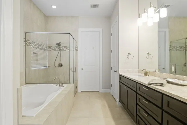 a spacious bathroom with a tub sink shower and mirror