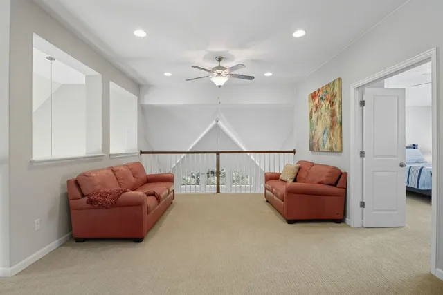 a living room with furniture and a ceiling fan