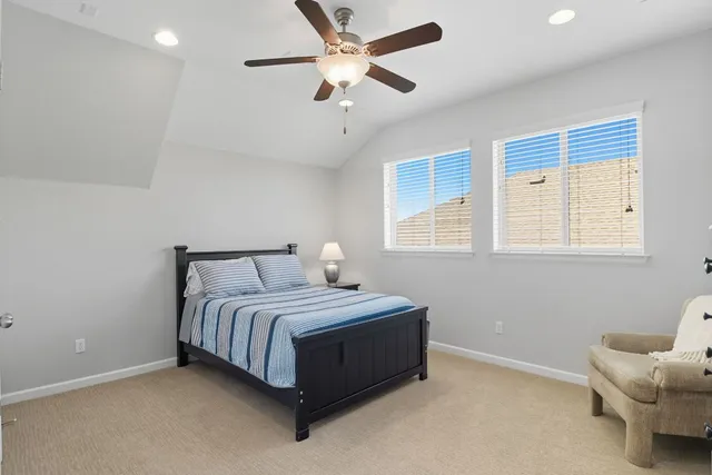 a bedroom with a bed and a ceiling fan