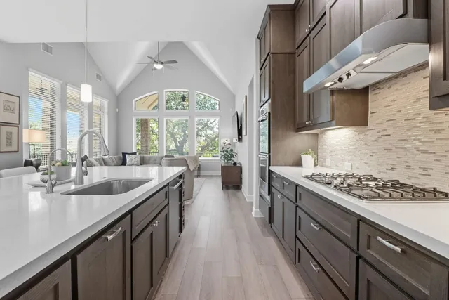 a kitchen with stainless steel appliances granite countertop a sink stove and cabinets