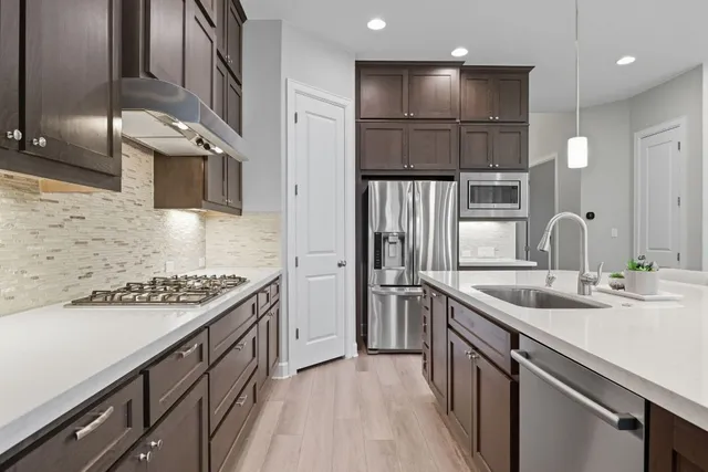 a kitchen with stainless steel appliances granite countertop a sink and a stove