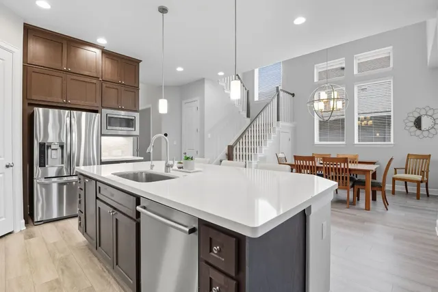 a kitchen with a stove a refrigerator a sink dishwasher with a dining table and chairs