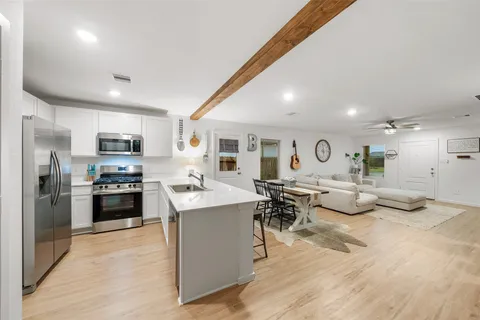 a kitchen with stainless steel appliances kitchen island granite countertop a stove and a sink