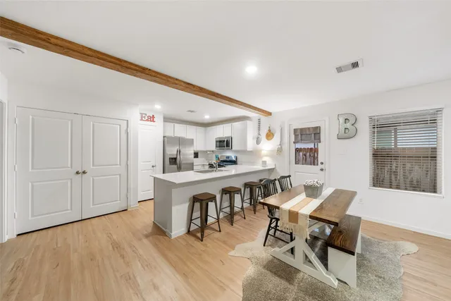 a living room with dining room and wooden floor