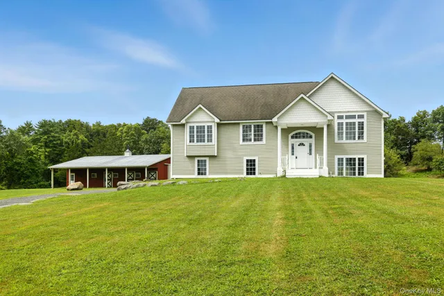 a view of a house with a big yard and large trees