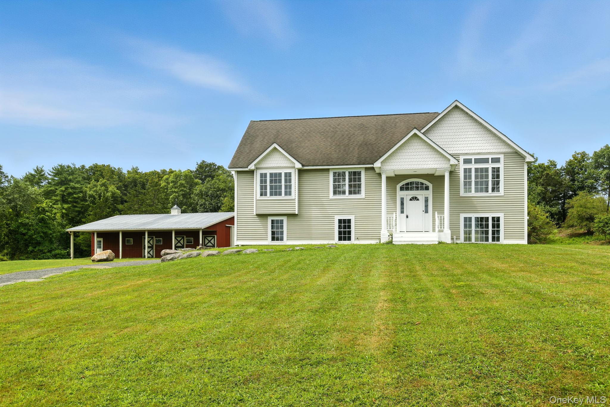 a view of a house with a big yard and large trees