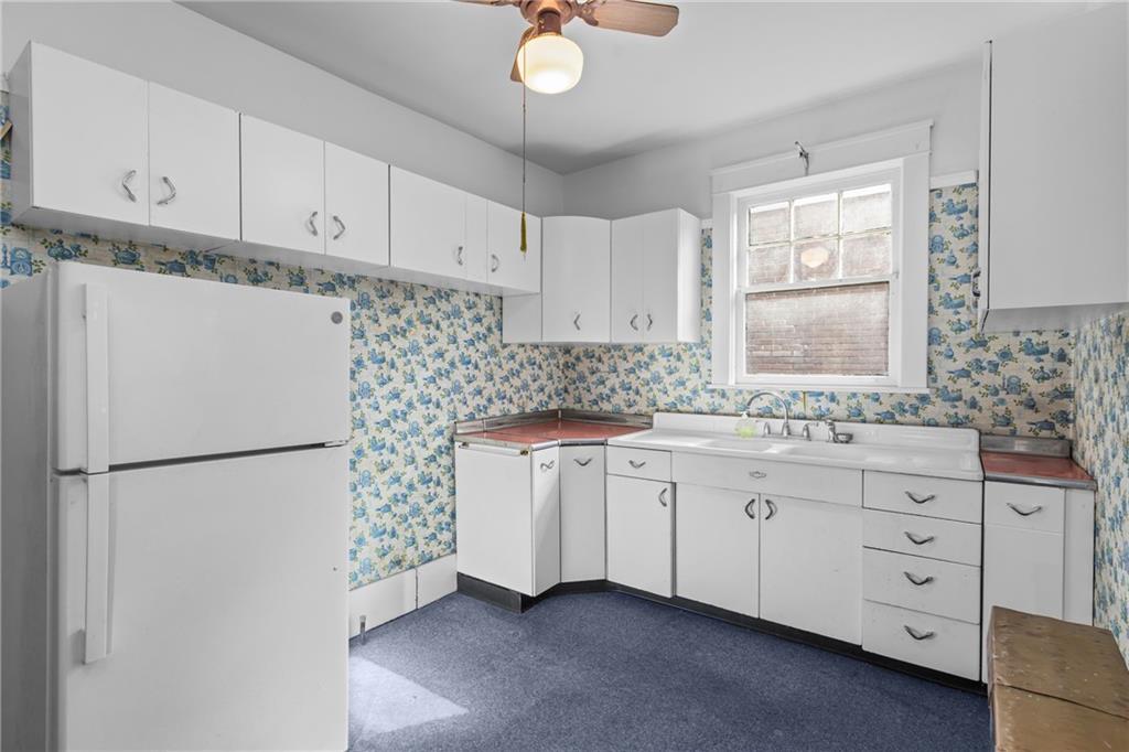 1050 Hiland Avenue Coraopolis, PA 15108 - Photo 15 of 33 a kitchen with sink refrigerator and cabinets
