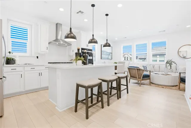 a kitchen with stainless steel appliances kitchen island granite countertop a sink a stove and white cabinets