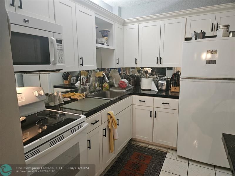a kitchen with stainless steel appliances a sink dishwasher stove microwave and cabinets