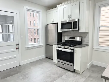 a kitchen with stainless steel appliances a stove a microwave and white cabinets