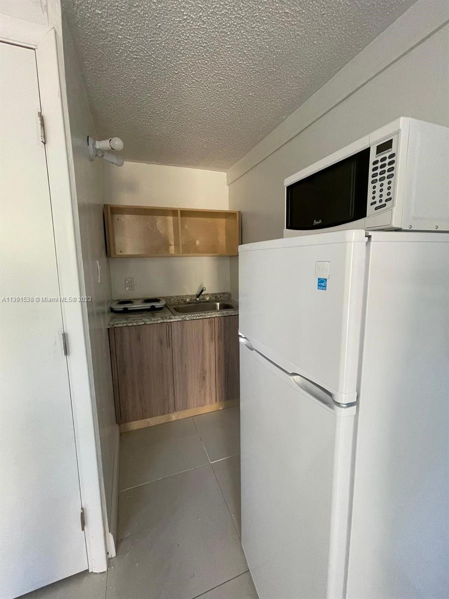 a white refrigerator freezer and a stove sitting inside of a refrigerator