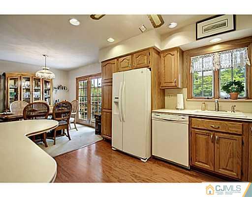 8 June Way Middlesex, NJ 08846 - Photo 11 of 25 a kitchen with stainless steel appliances granite countertop a refrigerator a sink dishwasher a dining table and chairs with wooden floor