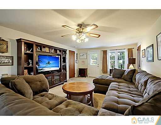 8 June Way Middlesex, NJ 08846 - Photo 7 of 25 a living room with furniture a chandelier and a flat screen tv