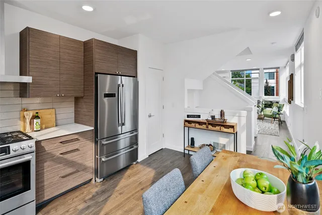 a kitchen with stainless steel appliances granite countertop a refrigerator a stove a sink dishwasher and cabinets with wooden floor