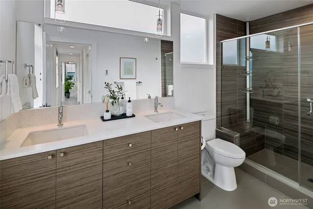 a bathroom with a double vanity sink toilet and shower