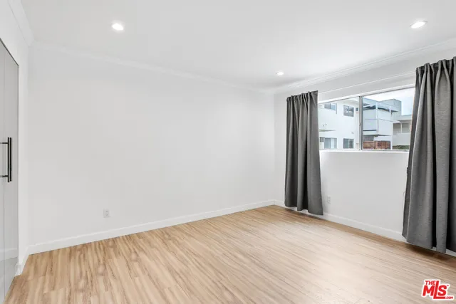 a view of a big room with wooden floor and windows