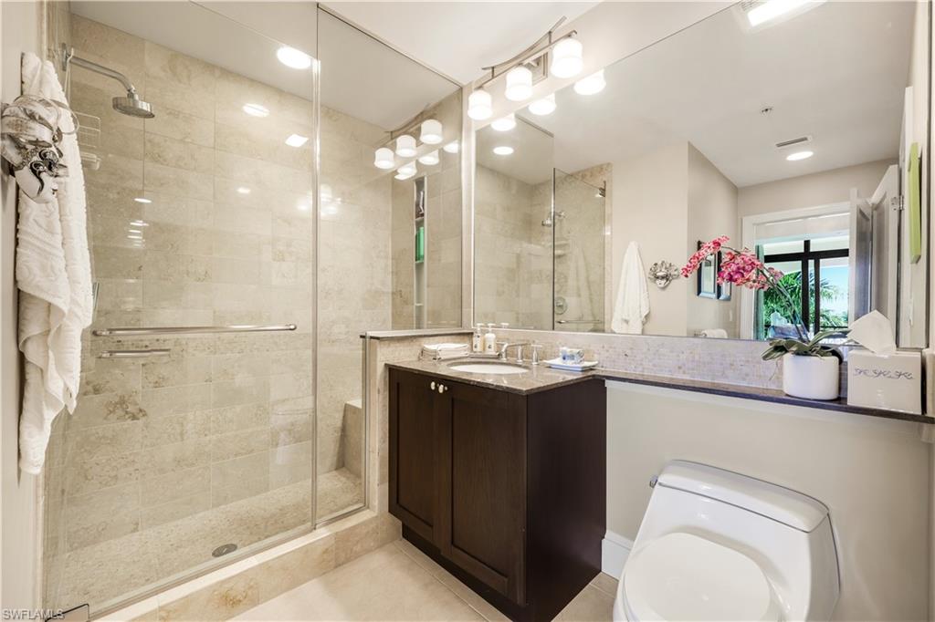 9115 Strada Place, Unit 5314 Naples, FL 34108 - Photo 17 of 49 a bathroom with a granite countertop sink a toilet a mirror and shower