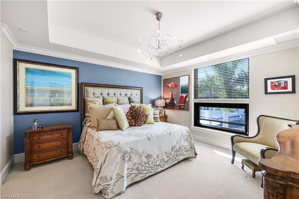 9115 Strada Place, Unit 5314 Naples, FL 34108 - Photo 18 of 49 a spacious bedroom with a bed and a chandelier