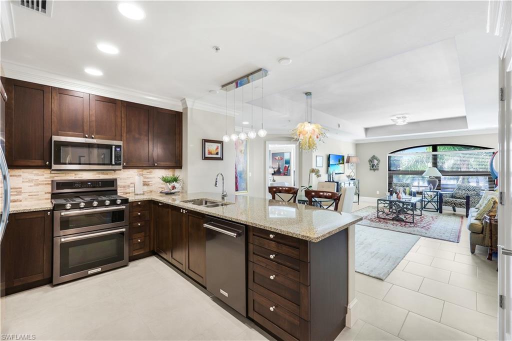 9115 Strada Place, Unit 5314 Naples, FL 34108 - Photo 5 of 49 a large kitchen with cabinets and stainless steel appliances