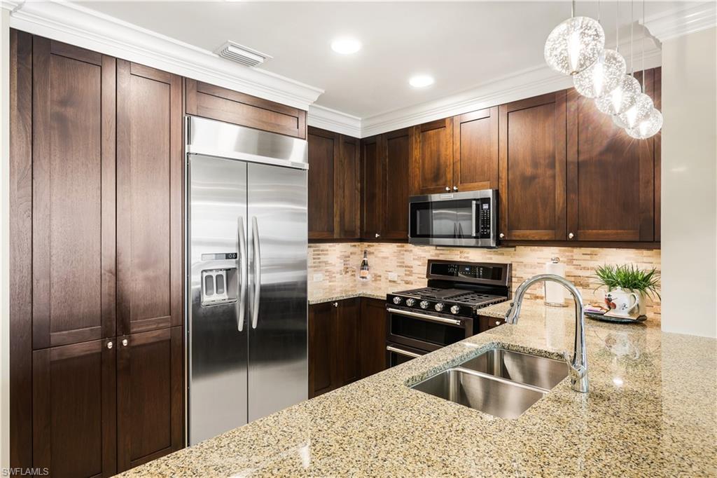9115 Strada Place, Unit 5314 Naples, FL 34108 - Photo 8 of 49 a kitchen with granite countertop a refrigerator and a sink