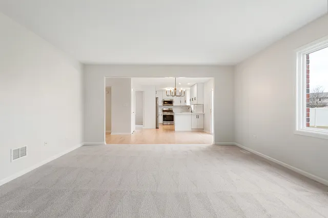 an empty room with a window and a fan