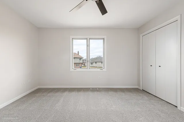 an empty room with closet and chandelier fan