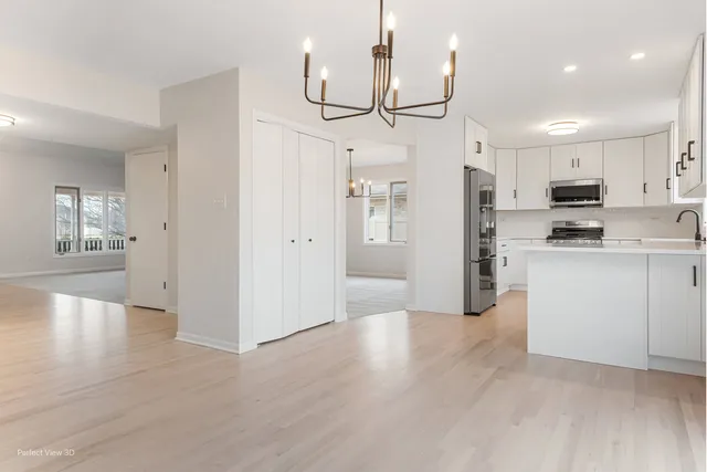 a kitchen with cabinets a sink and white stainless steel appliances