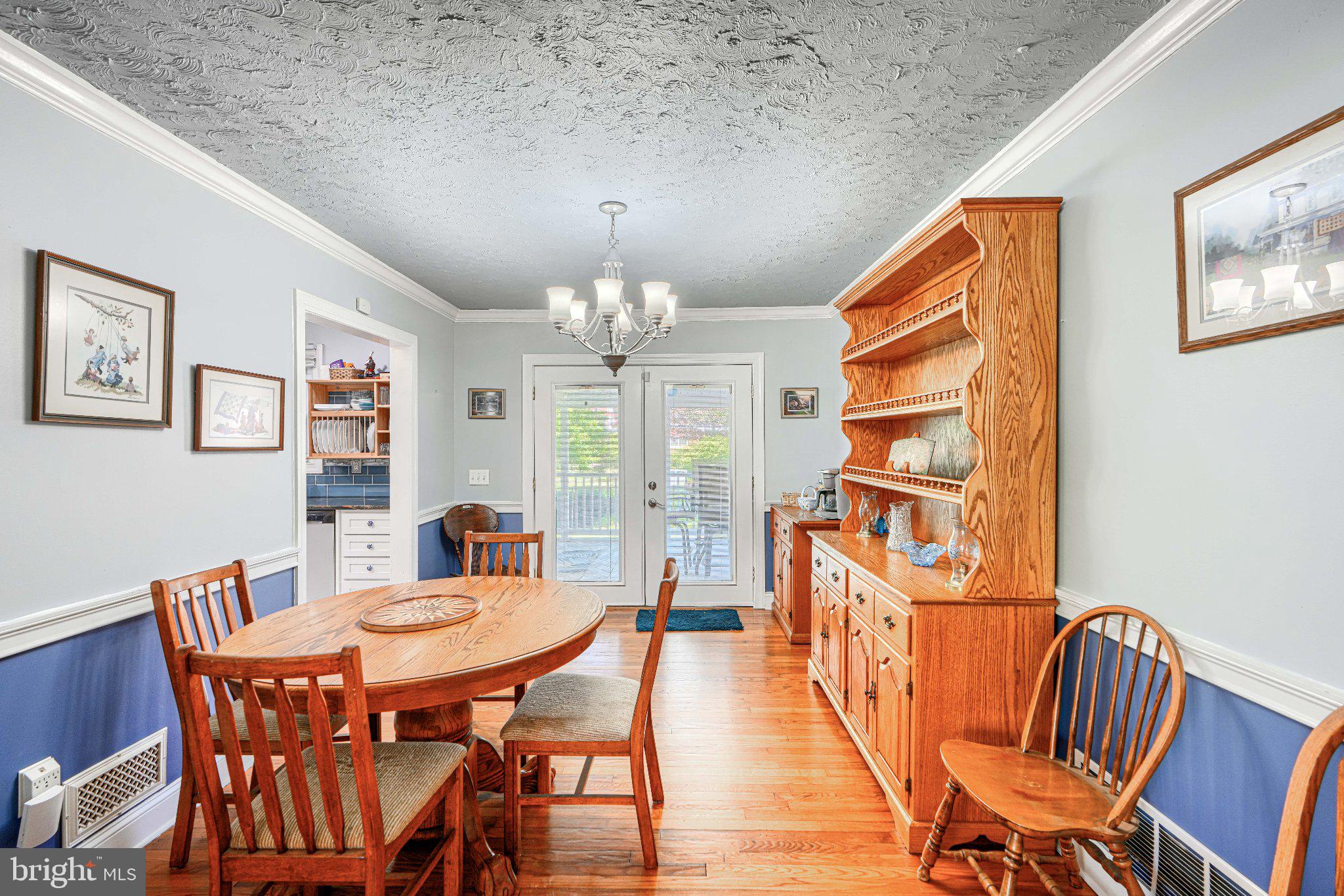 1234 St Andrews Way Baltimore, MD 21239 - Photo 19 of 38 a view of a dining room with furniture a chandelier and wooden floor