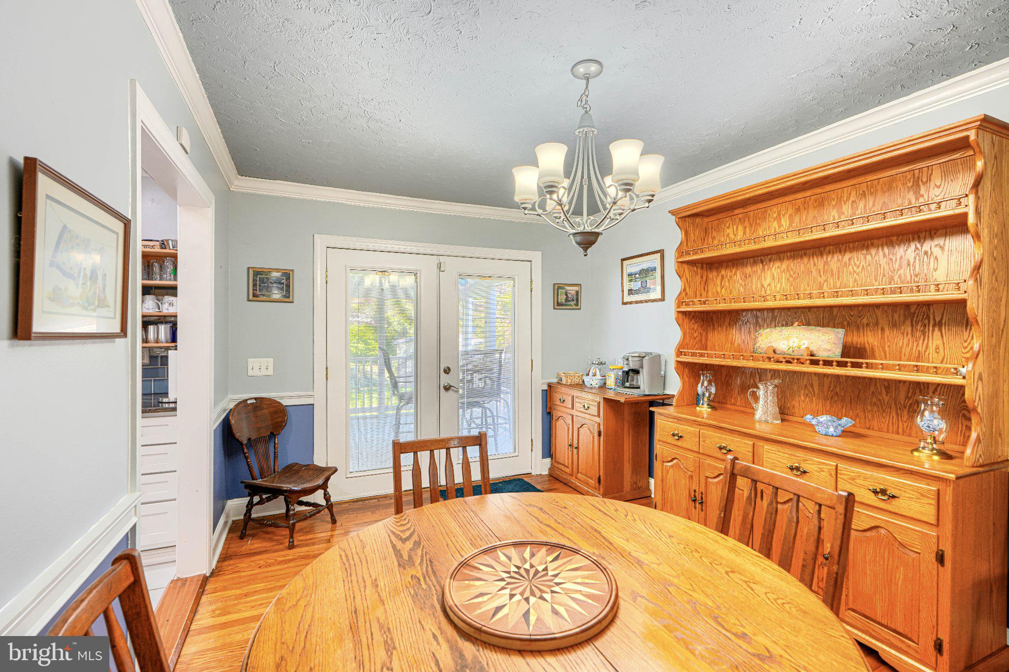 1234 St Andrews Way Baltimore, MD 21239 - Photo 20 of 38 a view of a livingroom with furniture a chandelier and wooden floor