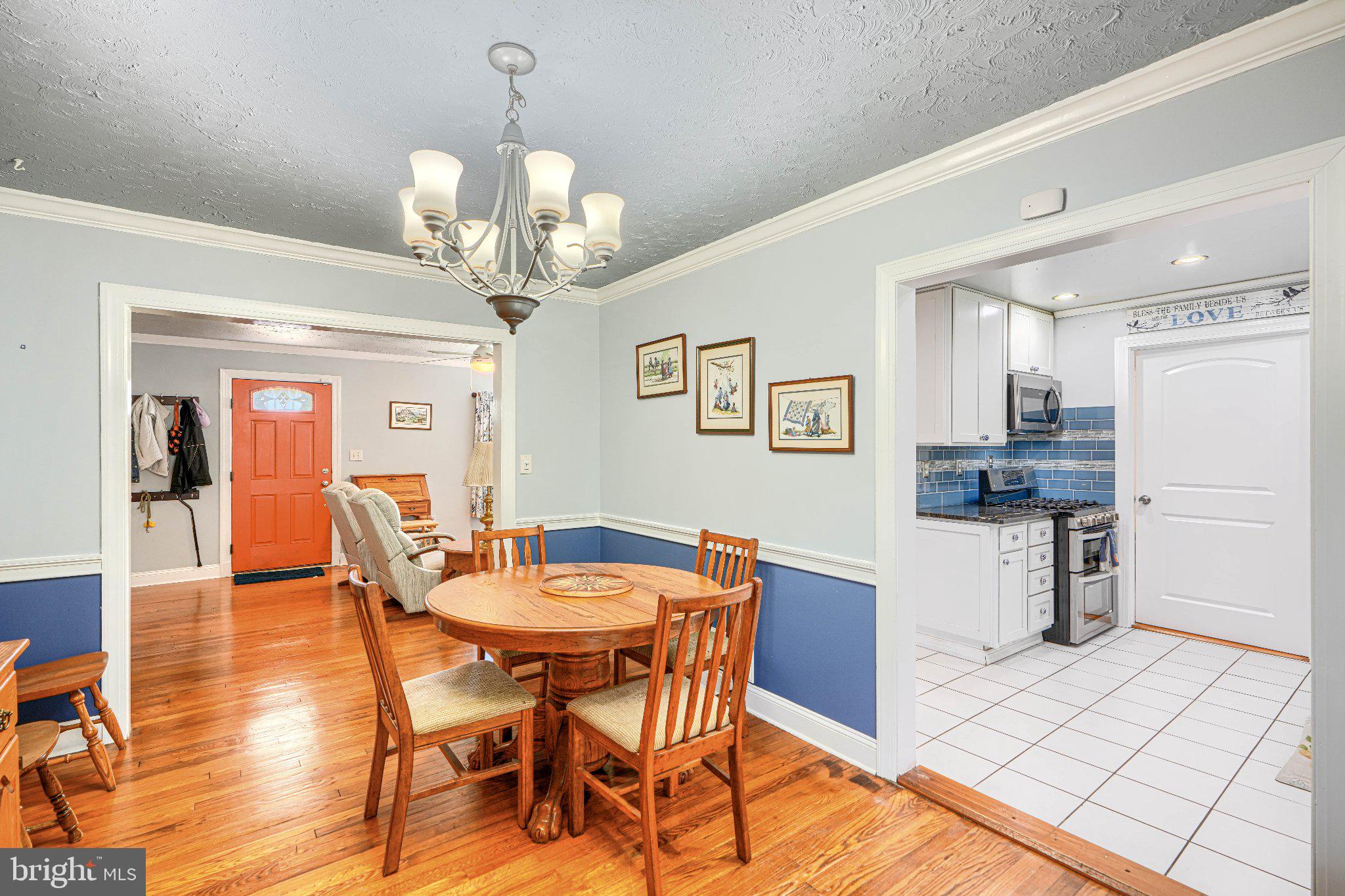 1234 St Andrews Way Baltimore, MD 21239 - Photo 23 of 38 a dining room filled a chandelier and kitchen view