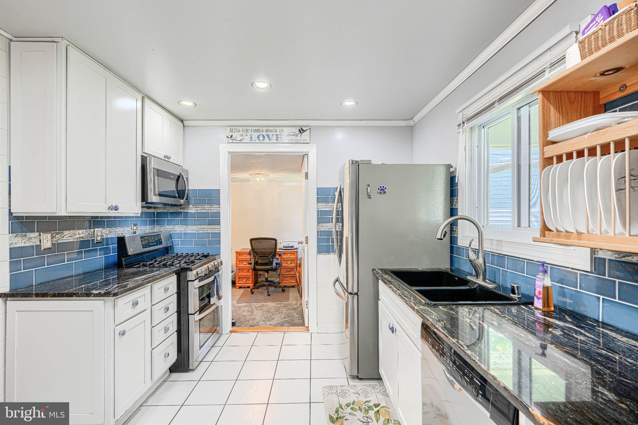 1234 St Andrews Way Baltimore, MD 21239 - Photo 25 of 38 a kitchen with stainless steel appliances granite countertop a stove a sink and a refrigerator