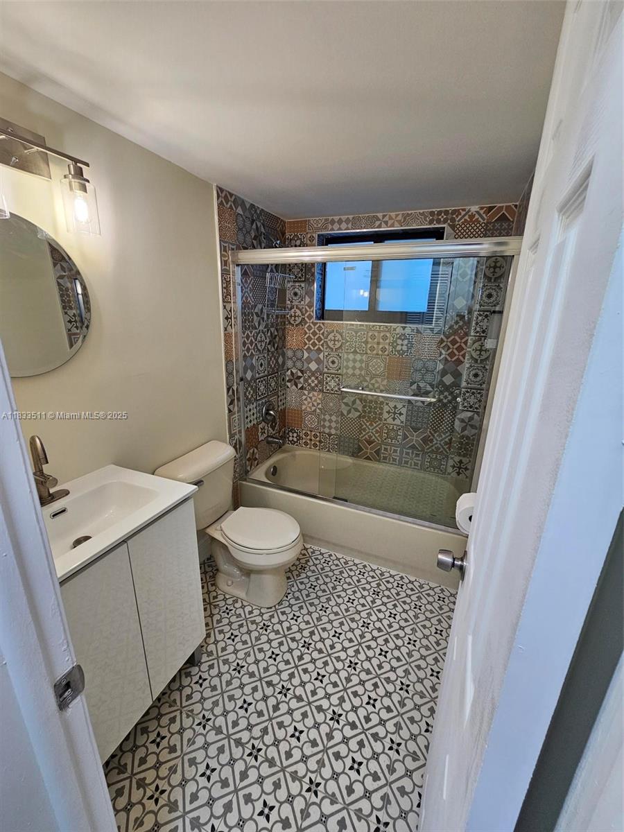 46 Northwest 35th Street, Unit 2 Miami, FL 33127 - Photo 20 of 21 a bathroom with a granite countertop sink a toilet a mirror and shower