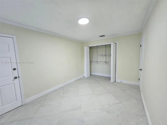 an empty room with a bathroom and a sink