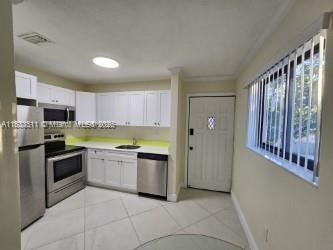 46 Northwest 35th Street, Unit 2 Miami, FL 33127 - Photo 9 of 21 a kitchen with stainless steel appliances granite countertop a stove a sink and a refrigerator